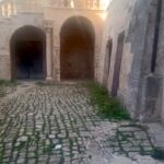 Il calpestio del chiostro del castello ducale invaso dall'erba